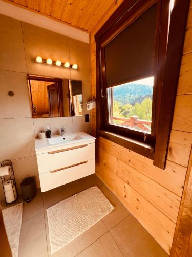 a bathroom with a sink and a window in a cabin at Malinowa Chata in Cisna