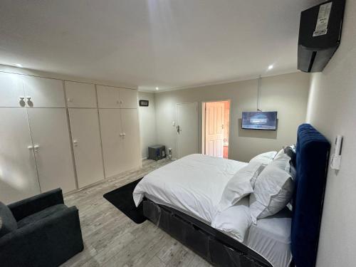 a bedroom with a bed and a couch and a television at Joy House in Cape Town