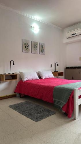 ein Schlafzimmer mit einem roten Bett mit zwei Kissen in der Unterkunft Departamento en pleno centro in San Miguel del Monte