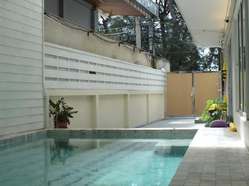 a swimming pool next to a house with at Areava Pool Villa Cha-am บ้านพักชะอำ พูลวิลล่า ติดชายหาดชะอำ in Cha Am