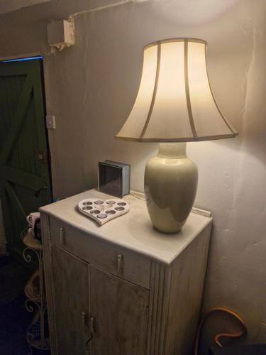 a lamp sitting on top of a table with a clock at charming rustic stable conversion 