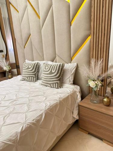 a bedroom with a bed with a headboard and pillows at Chic & Cozy Apartment for a Comfortable Stay Fes in Fès