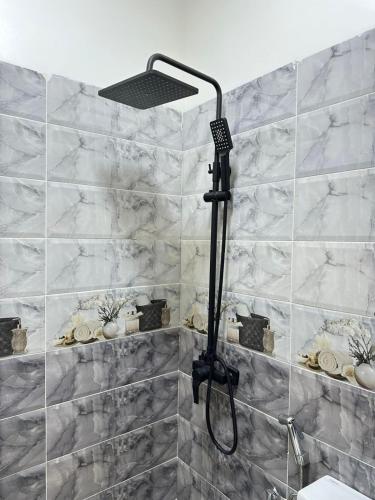 a shower with a shower head in a bathroom at Chic & Cozy Apartment for a Comfortable Stay Fes in Fès