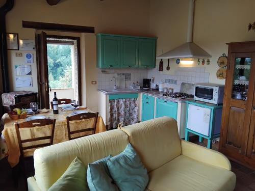 a living room with a couch and a kitchen with green cabinets at Tre Archi in Grumale