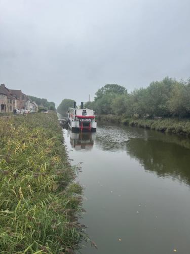 a boat is docked on the side of a river at The Green Mile in Aalter