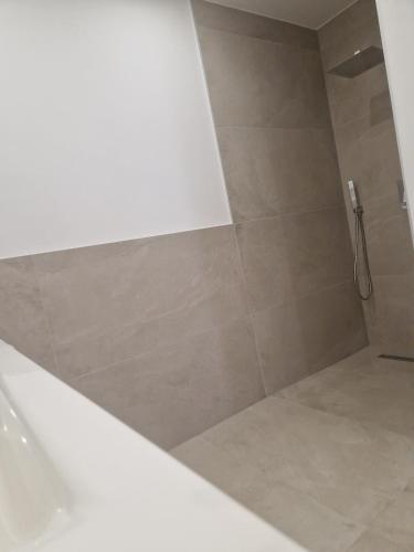 a bathroom with a shower with a tiled floor at Lakeside Ferienhaus Neusiedl am See in Neusiedl am See