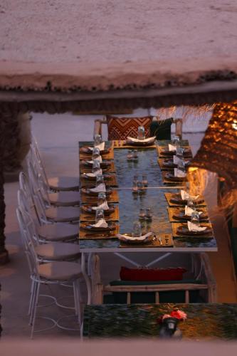 a long table with chairs and food on it at Agafay Desert Hotel in El Karia