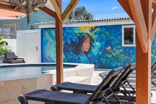 a mural on a wall next to a swimming pool at Caribe CBW Hotel in Willemstad