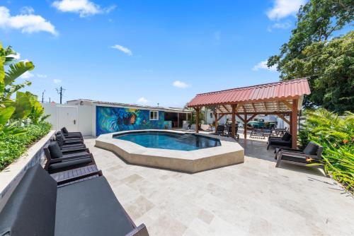 a swimming pool in a patio with a gazebo at Caribe CBW Hotel in Willemstad