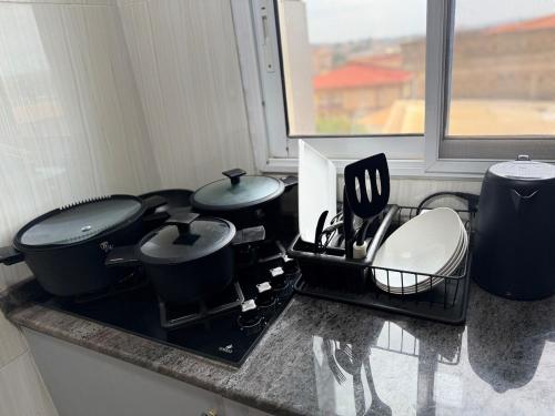 a kitchen with two pots and pans on a stove at La Maison H - Studio Haut Standing in Yaoundé