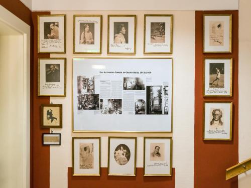 a wall of pictures on a wall at Graben Hotel in Vienna