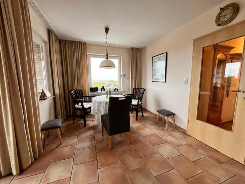 a dining room with a table and chairs at Apartment CAPTAIN'S LODGE in Norddeich