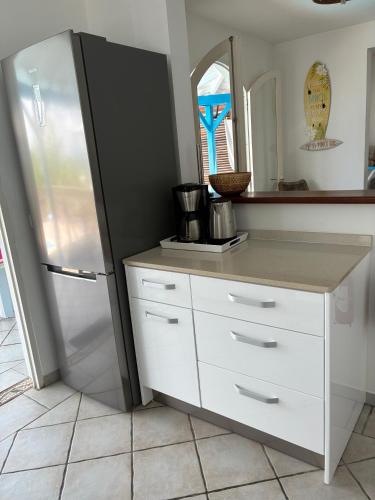 a kitchen with a refrigerator and a counter at Villa Crève Cœur in Sainte-Anne