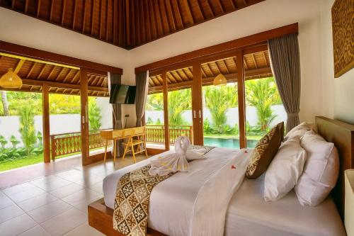 a bedroom with a large bed and a balcony at Ubud Forest Villa with Private Pool and Kitchen in Payangan
