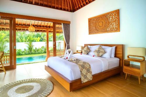 a bedroom with a bed and a balcony at Ubud Forest Villa with Private Pool and Kitchen in Payangan