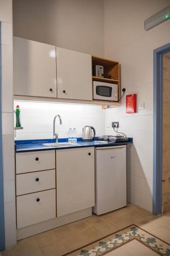 a kitchen with a sink and a microwave at Casa San Carlo in Valletta