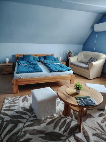 a bedroom with a bed and a table and a couch at Silye Vendégház in Hortobágy