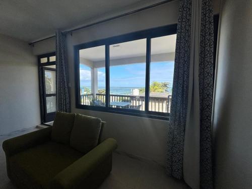a living room with a chair and a large window at Lakaz Peser in Saint-Martin