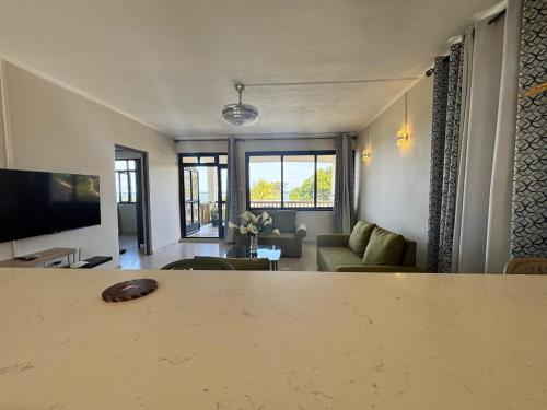 a living room with a table and a couch and a television at Lakaz Peser in Saint-Martin