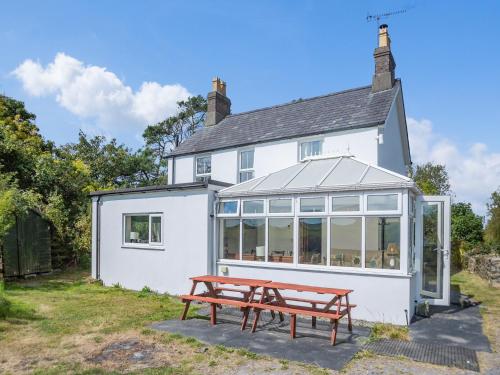 a white house with a picnic table in front of it at Brynawel in Bryncroes