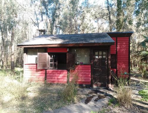 an old red shed in the middle of a forest at Galilea in San Miguel del Monte