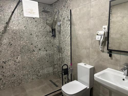 a bathroom with a toilet and a sink at Grand Way Hotel in Taraz