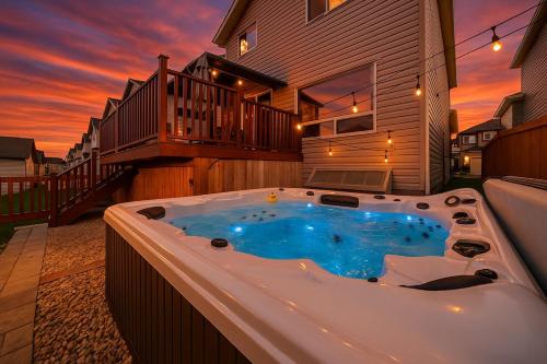 a jacuzzi tub in the backyard of a house at 5BD Jungle Oasis - HotTub - BBQ - King Bed - Games - Garage in Edmonton