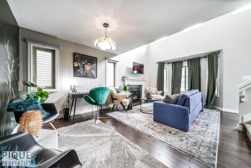 a living room with a blue couch and chairs at 5BD Jungle Oasis - HotTub - BBQ - King Bed - Games - Garage in Edmonton