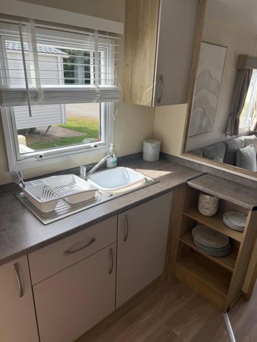 a bathroom with a sink and a window at Tattershall lakes country park The Fairways in Tattershall
