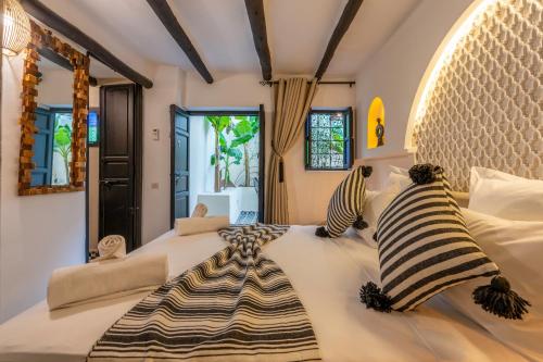 a bedroom with a large bed with zebra pillows on it at Dar Bonita in Marrakech