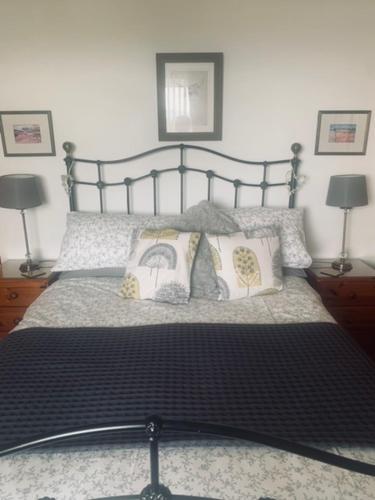 a bedroom with a bed with pillows and two lamps at Mo-Dhachaidh B&B in Poolewe