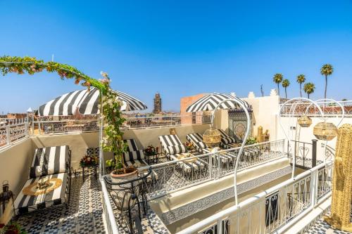 a balcony with tables and chairs on a building at Dar Bonita in Marrakech