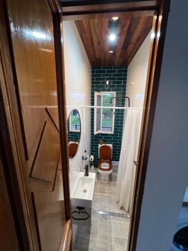 a bathroom with a sink and a toilet and a mirror at La Puertita de Acantilados in Mar del Plata