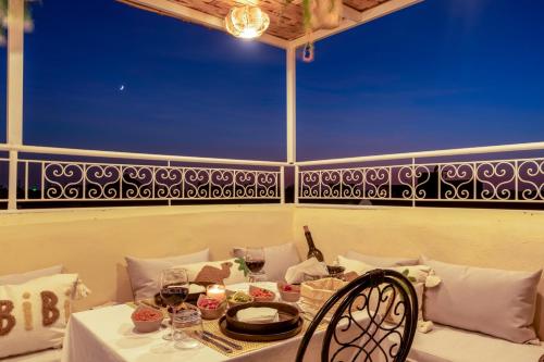 a table with a white table cloth and wine glasses at Dar Bonita in Marrakech