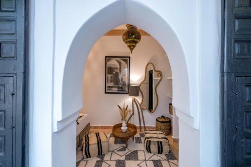 a hallway with an archway with a table and chairs at Dar Bonita in Marrakech
