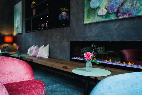 a living room with a fireplace and a red couch at Landgasthof Hotel Linde in Stumm
