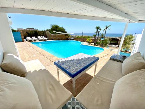 a view of a swimming pool with chairs and a table at LES OLIVIERS Villa N2 avec piscine privée in Oualidia