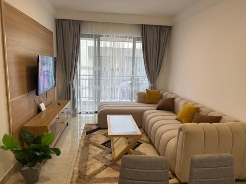 a living room with a large couch and a television at Niva house in Ruaka