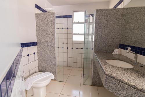 a bathroom with a toilet and a sink at Honorato Hotel by Easy Hotéis in Rio Verde