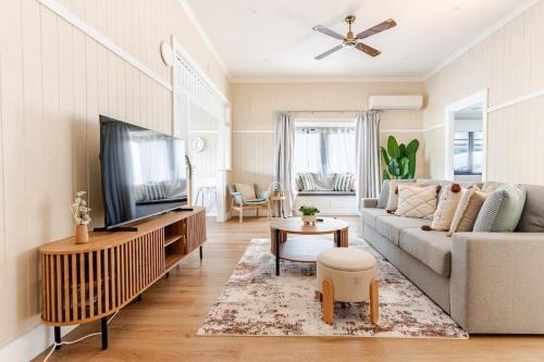 a living room with a couch and a tv at A5Q Abnb-Style 3BR House with Balcony & 2 Free Parking Nr Portside Wharf in Brisbane
