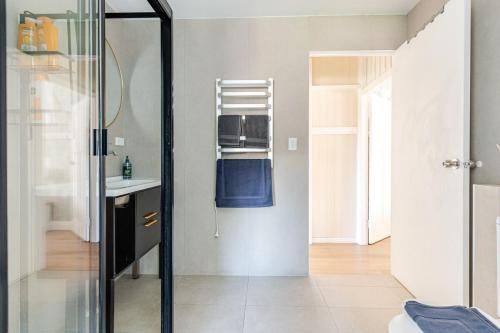a bathroom with a sink and a glass shower door at A5Q Abnb-Style 3BR House with Balcony & 2 Free Parking Nr Portside Wharf in Brisbane