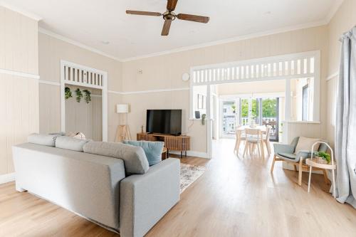a living room with a couch and a tv at A5Q Abnb-Style 3BR House with Balcony & 2 Free Parking Nr Portside Wharf in Brisbane