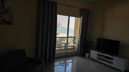 a living room with a television and a view of the ocean at Luxury casino & beach studio in Ras al Khaimah