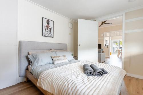 a bedroom with a bed with two slippers on it at A5Q Abnb-Style 3BR House with Balcony & 2 Free Parking Nr Portside Wharf in Brisbane