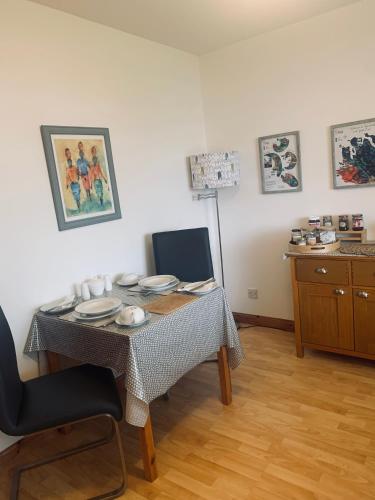 a dining room with a table with plates on it at Mo-Dhachaidh B&B in Poolewe