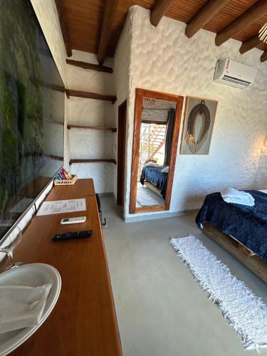 a bathroom with a sink and a mirror in a room at Pousada Suyhê in Caraíva