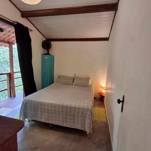 a bedroom with a bed in the corner of a room at Pachamama suite no centro de Lumiar in Lumiar