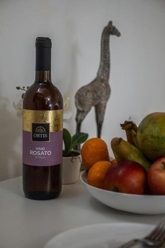 a bottle of wine next to a bowl of fruit at Casa San Carlo in Valletta
