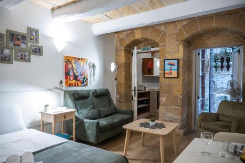 a room with a bed and a couch and a table at Casa San Carlo in Valletta