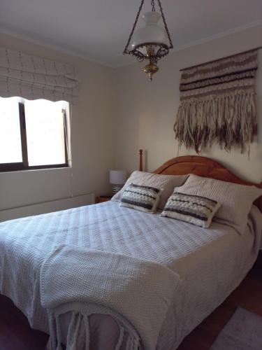 a bedroom with a large bed with two pillows at Nevados de chillan , edificio los coigues in Nevados de Chillan